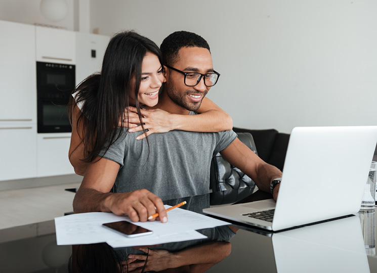 Man and woman looking at laptop smiling