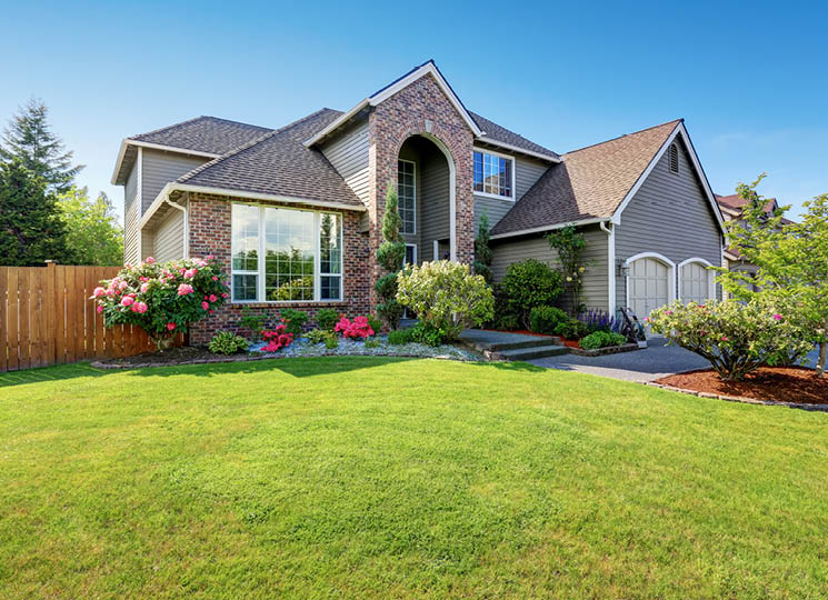 Large house with a green front yard on a sunny day
